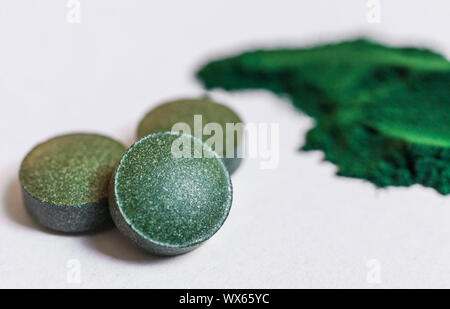 Spirulina Tabletten Tabletten Makro Foto gegen den weißen Hintergrund. Stockfoto