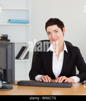 Porträt einer Sekretärin der Eingabe auf Ihrer Tastatur in Ihrem Büro Stockfoto