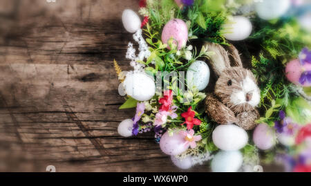 Ostern Kranz mit bunten Eiern und Blumen und ein Kaninchen in der Mitte Stockfoto