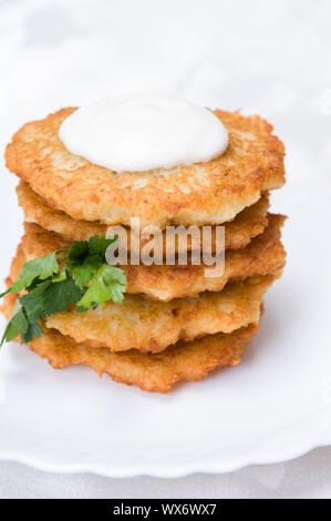 Gebratene Kartoffelpuffer mit Petersilie auf weiße Platte Stockfoto