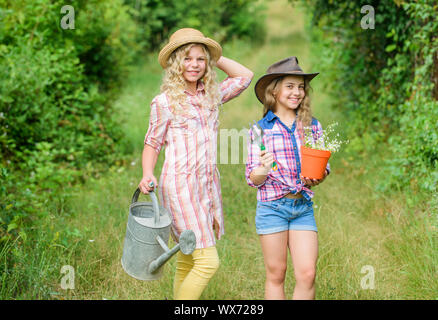 Sie wissen alles über Blumen. kleine Mädchen Bauer im Dorf. Kinder Gartengeräte halten. Feder Land. Tag der Erde. Sommer Familie Bauernhof. Ökologie und Umweltschutz. Stockfoto