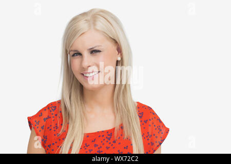 Hübsche Blondine in orange Kleid vor weißem Hintergrund Stockfoto