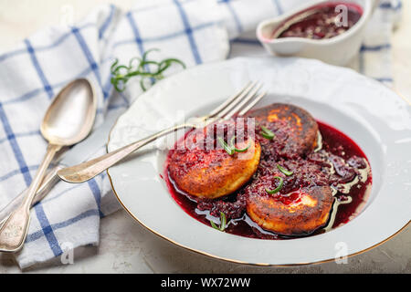 Quark Krapfen mit kirschsauce und Rosmarin. Stockfoto