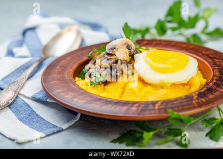 Polenta mit karamellisierten Pilze, Ei und Petersilie. Stockfoto