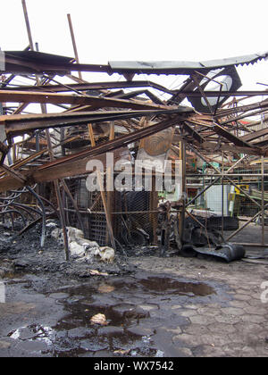 Twisted Stahlträgern nach einer Fabrik Feuer. Lager zerstört durch Feuer. Twisted Metal, Haufen von Schutt und Asche verbrannt. Stockfoto