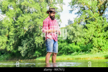 Eine Art der Meditation. Fische in der Regel in freier Wildbahn gefangen. Trout Farm. Hobby Sport. Ruhige und friedliche Stimmung. Fischer allein im Wasser des Flusses. Mann bärtigen Fischer. Fischer Angelausrüstung. Stockfoto