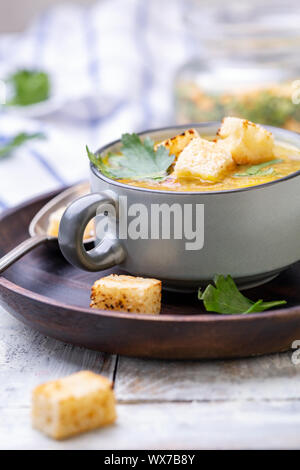 Erbsensuppe mit geräuchertem Rippchen und Croutons in eine Schüssel geben. Stockfoto