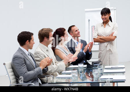 Lächelnd Geschäft Leute applaudieren ein Kollege nach einer Präsentation Stockfoto