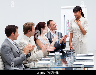 Lächelnd Business Team applaudieren ein Kollege nach einer Präsentation Stockfoto