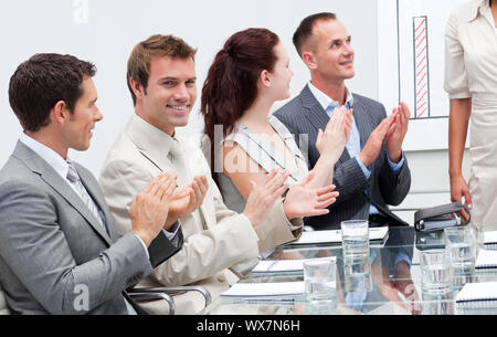 Lächelnd Geschäft Leute applaudieren ein Kollege nach einer Präsentation Stockfoto