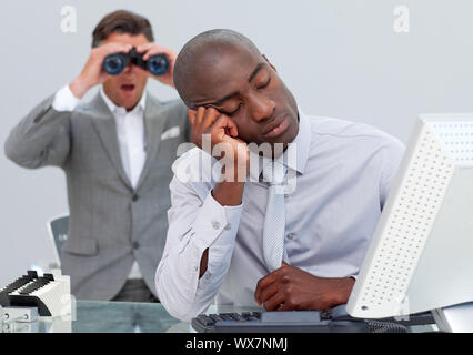 Schlafend Geschäftsmann von einem Mann auf der Suche durch ein Fernglas im Büro gestört Stockfoto