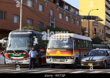 LIMA, PERU - September 13, 2011: Busse und ein Taxi stehend auf rotes Licht mit einem Bus Leiter stehend auf der Avenida Diagonal ruft für Passagiere o Stockfoto