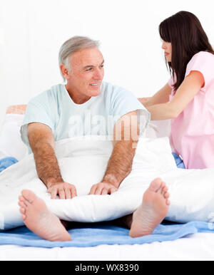 Aufmerksame Krankenschwester Bett ihrer Patienten zur Festsetzung in einem Krankenhaus Stockfoto
