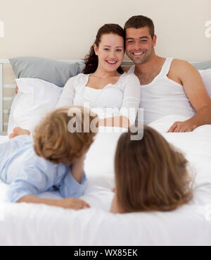 Brüder und Eltern gemeinsam im Bett liegend Stockfoto