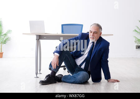 Alter Geschäftsmann Yoga Übungen im Büro Stockfoto