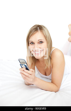 Porträt einer jolly Frau sms liegen auf ihrem Bett Stockfoto