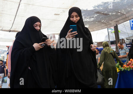 Muslimische Frauen einen Blick auf ihre Mobiltelefone im Stadtteil Fatih Istanbul Stockfoto