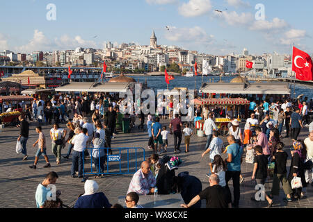 Fußgänger und Fisch Restaurants neben der Galata Brücke in Istanbul, Türkei Stockfoto