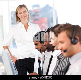 Schöne weibliche Führer mit einer Mannschaft auf ein Call Center Stockfoto