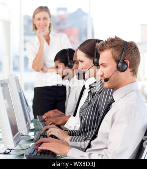 Ernsthafte Anführerin mit einem Team auf ein Call-center Stockfoto