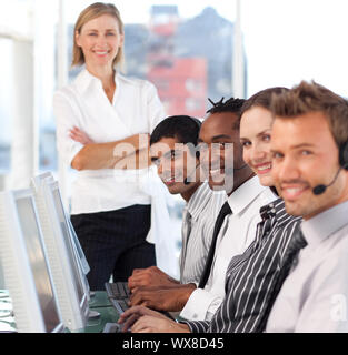 Weibliche Führer mit Ihrem Team auf eine Call Center konzentriert Stockfoto