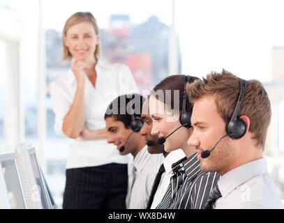 Weibliche Führer mit einer Mannschaft auf ein Call Center konzentriert Stockfoto