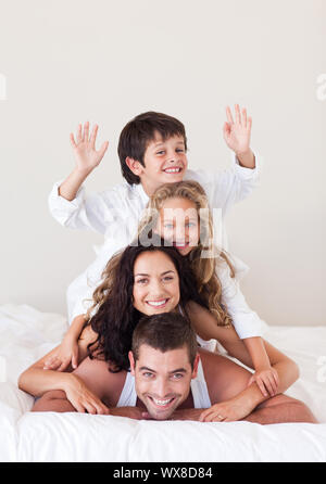 Fröhliche Familie auf ihrem Bett liegend Stockfoto