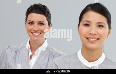 Multi-ethnischen Geschäftsfrauen in einer Linie in die Kamera lächeln Stockfoto
