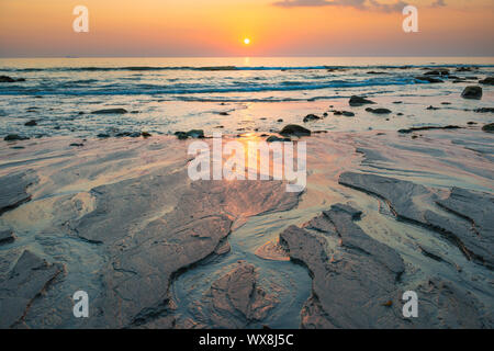 Sunset Landschaft mit Strand, Sonne und Steine im Sea Shore Stockfoto