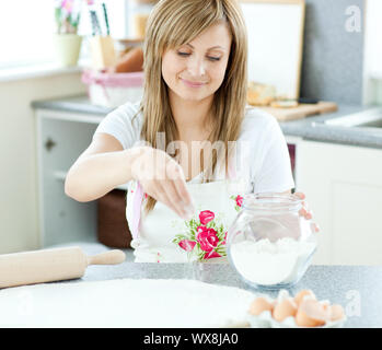 Porträt einer jungen Frau einen Kuchen in der Küche zu Hause. Stockfoto