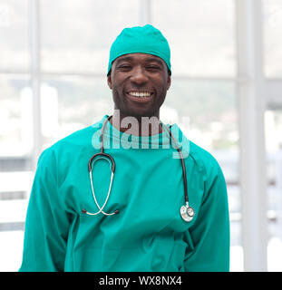 Porträt eines lächelnden Arzt in Grün scrubs in einem Krankenhaus Stockfoto