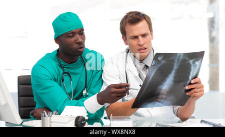 Junge Arzt und Chirurg, der eine x-ray in einem Krankenhaus konzentriert Stockfoto