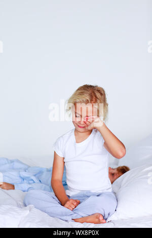 Junges Mädchen sitzen auf dem Bett trägt einen Pyjama Stockfoto