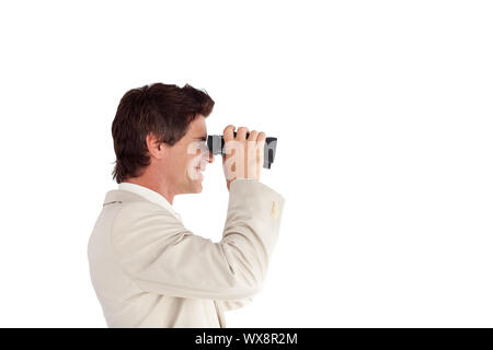 Lächelnd Geschäftsmann mit Fernglas vor weißem Hintergrund Stockfoto