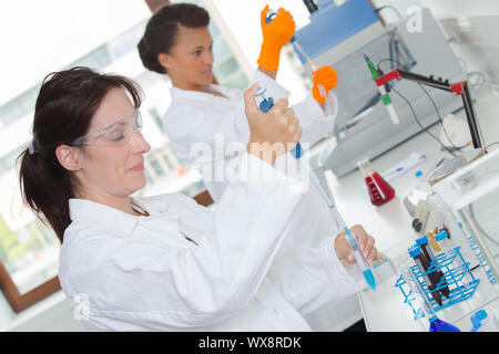 Wissenschaftlerinnen mit Pipetten im Labor Stockfoto