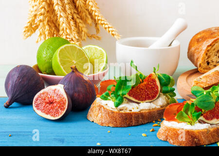 Toast von Schweizer twisted Brot, mit Feta oder Ricotta, frische Feigen, gerollt Scheibe Speck, frische Blätter von Mais oder baldrian Salat und zerdrückten Pis Stockfoto