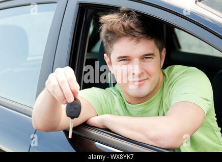 Animierte kaukasischen Mann hält einen Autoschlüssel in seinem Auto sitzen Stockfoto