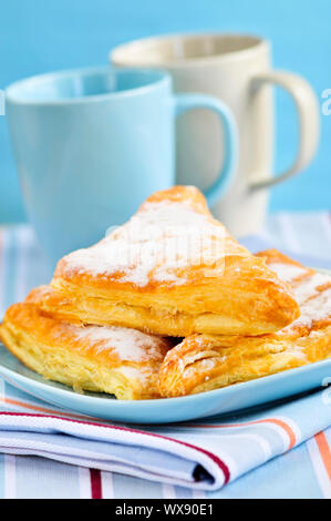 Apple-Umsätze-Gebäck mit Kaffeetassen im Hintergrund Stockfoto