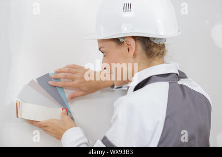 Junge Frau mit ein Farbmuster mit einem Maler Malerei Stockfoto