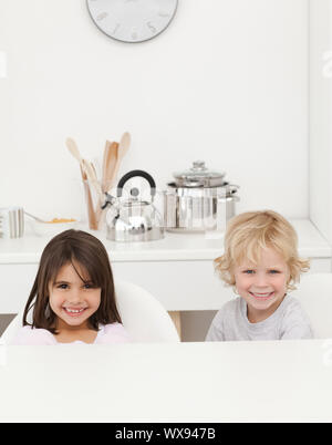 Gerne Bruder und Schwester ihr Frühstück in der Küche sitzen warten Stockfoto