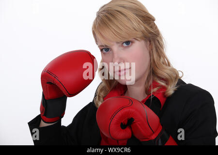 Eine Geschäftsfrau mit Boxhandschuhen auf. Stockfoto