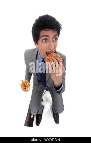 Geschäftsmann entjungfern ein Burger und Pommes frites Stockfoto