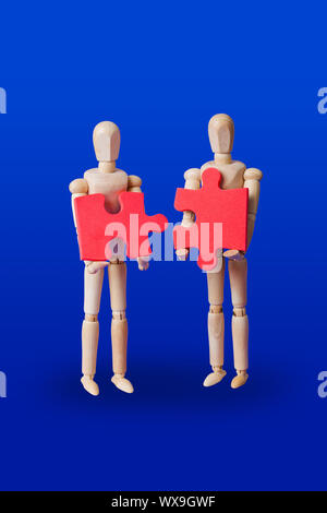 Holzspielzeug Figuren mit Puzzle auf Blau Stockfoto