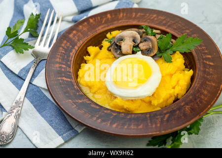 Polenta mit karamellisierten Pilze, Ei und Petersilie. Stockfoto