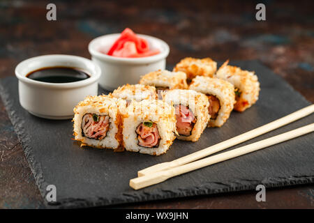 Japanisches Sushi auf einem rustikalen dunklen Hintergrund. Stockfoto