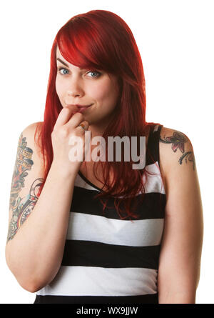 Schüchterner junge weiße Frau mit roten Haaren und Tattoo am Arm Stockfoto