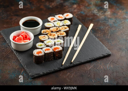 Japanisches Sushi auf einem rustikalen dunklen Hintergrund. Stockfoto
