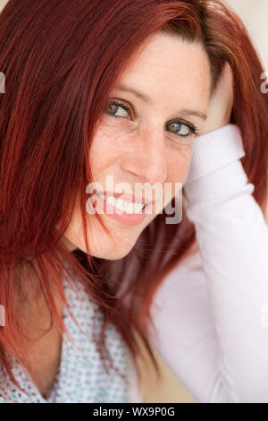 Closeup ausdrucksstarkes Portrait von einem niedlichen rothaarigen Frau trägt einen weißen Pullover, und wenn man die Kamera Stockfoto