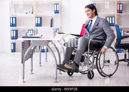 Jungen gutaussehenden Mitarbeiter im Rollstuhl die Arbeit im Büro Stockfoto
