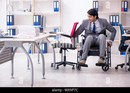 Jungen gutaussehenden Mitarbeiter im Rollstuhl die Arbeit im Büro Stockfoto